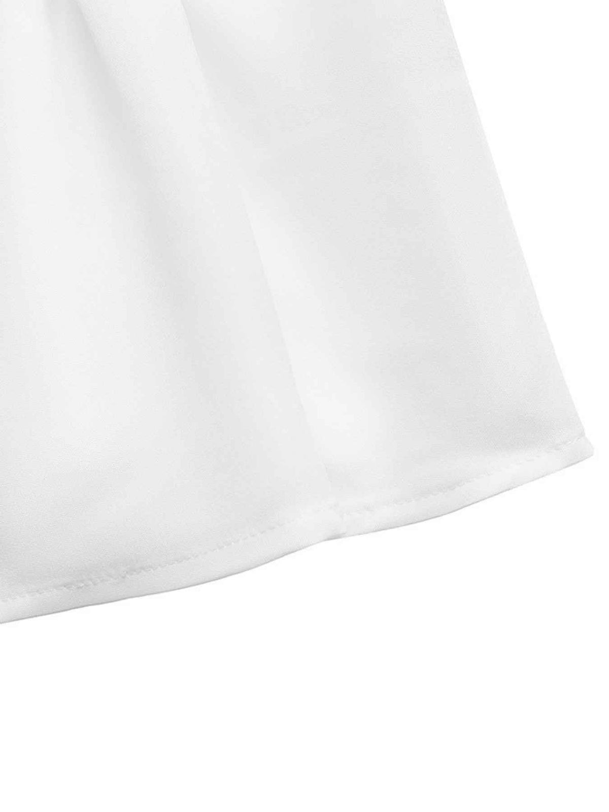 Close-up of a white fabric surface with a folded hem and soft shadows on a white background.