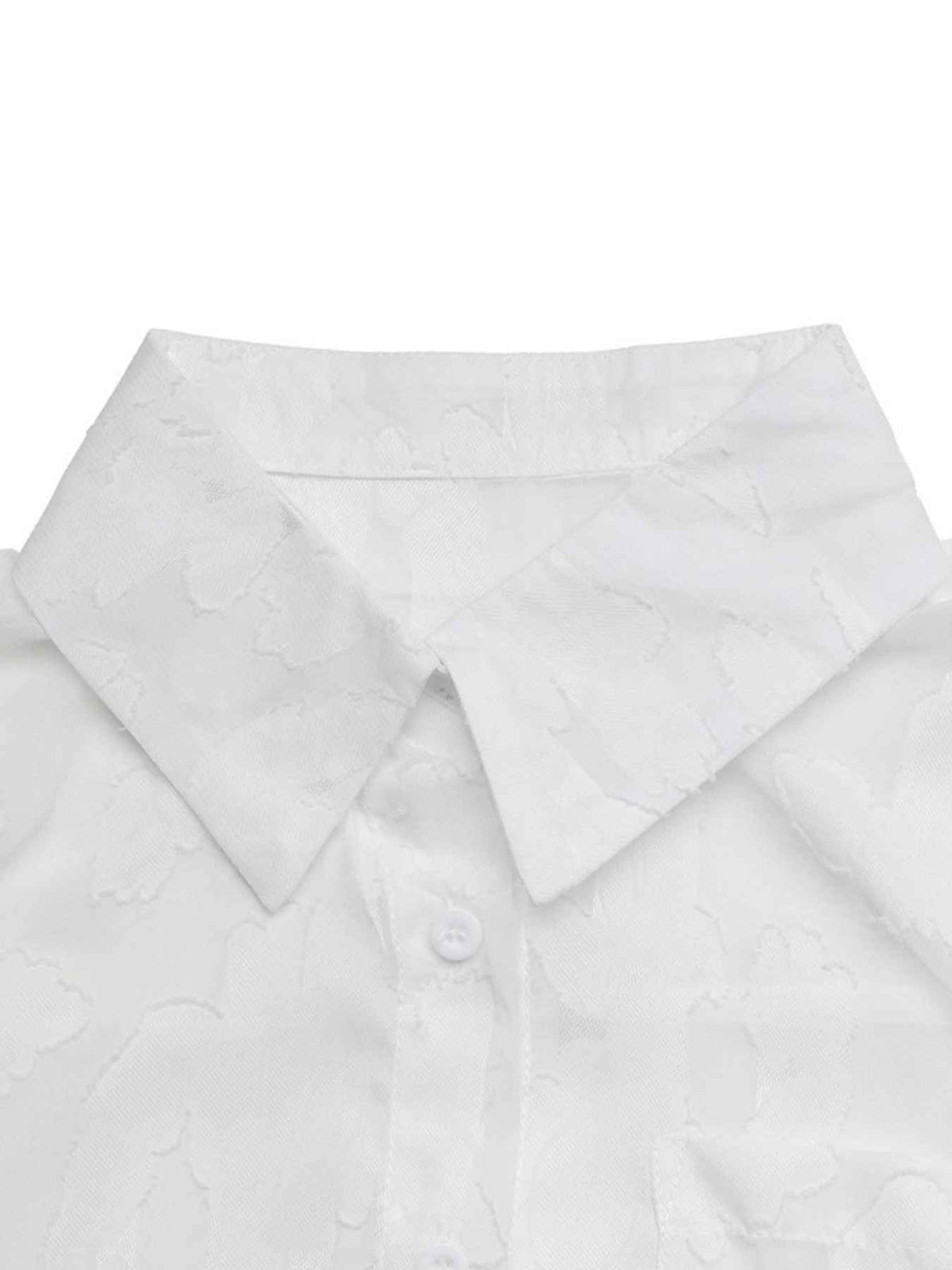 Close-up of a white collared button-up shirt with a subtle tonal jacquard pattern, showing the collar and upper front placket on a plain white background.