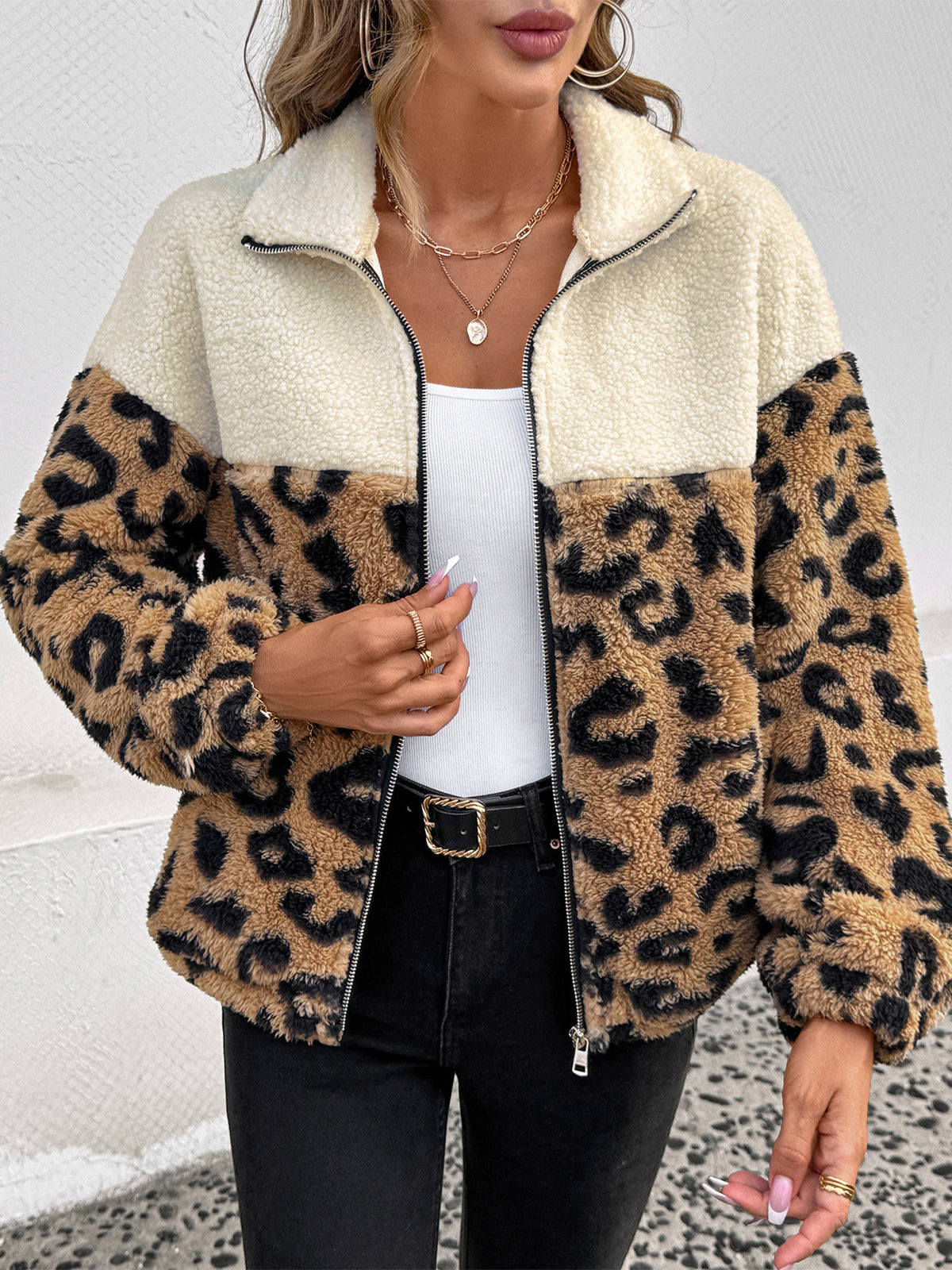 Women's cream and leopard print teddy fleece jacket with front zip, worn open over a white top and black jeans
