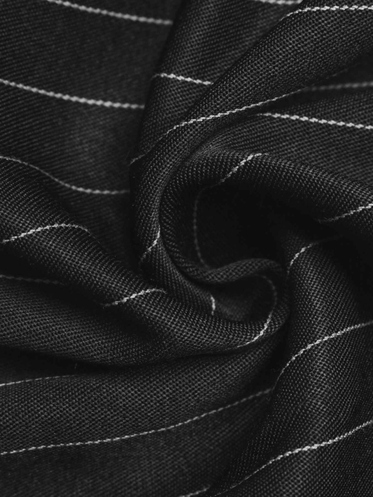 A close-up of black fabric with thin white pinstripes, arranged in a spiral drape to show the material texture.