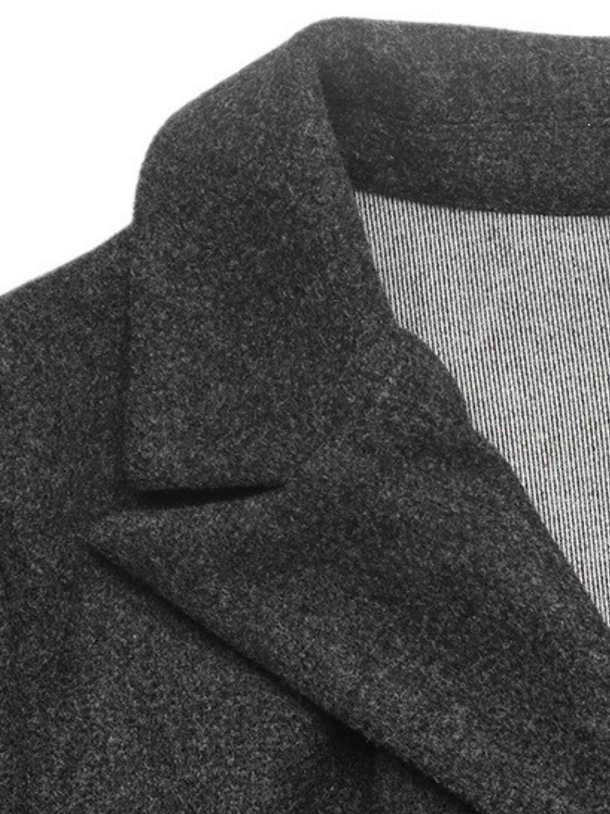 Close-up of a dark charcoal gray textured fabric garment, showing the collar and folded lapel detail against a white background.