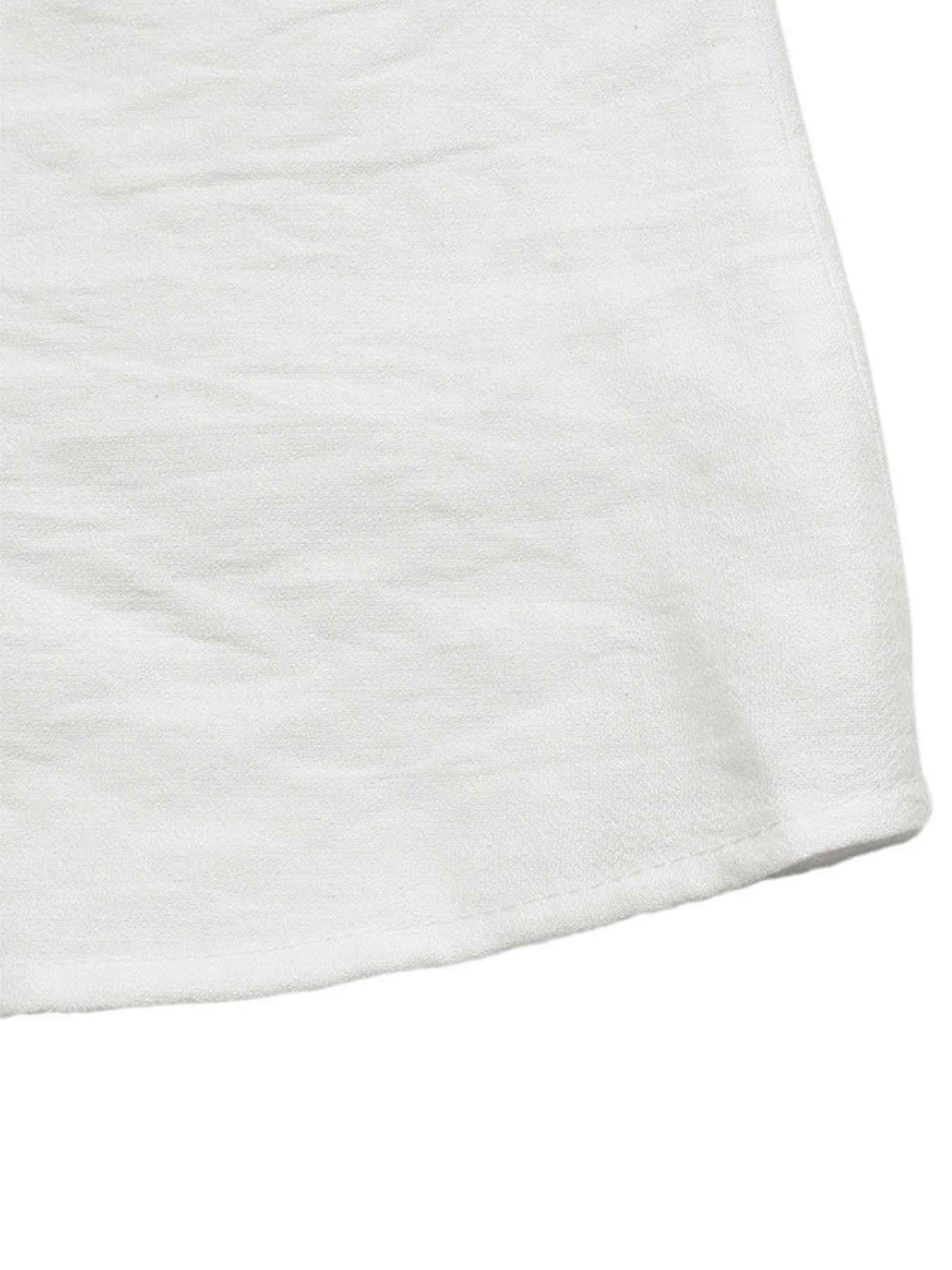 A close-up of a white textured fabric, showing the soft woven material and folded hem against a plain white background.