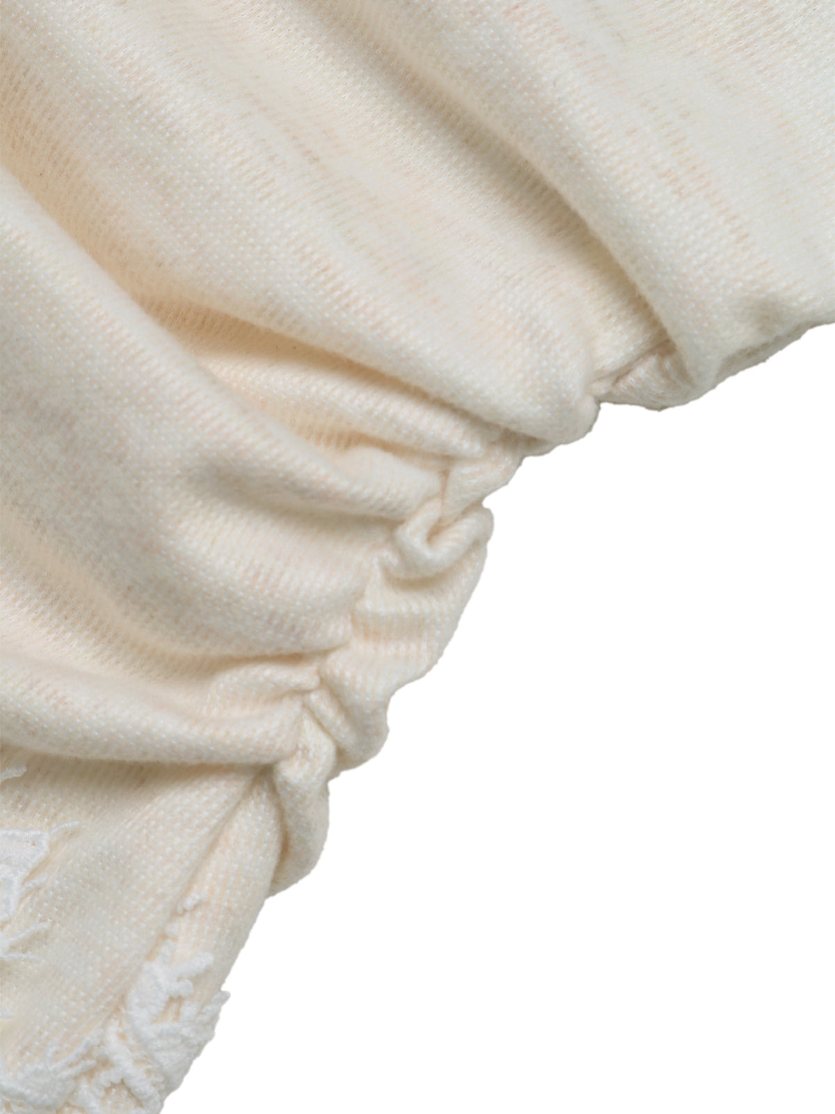 Close-up of a cream-colored textured fabric with gathered ruching and a frayed edge, shown against a plain white background.