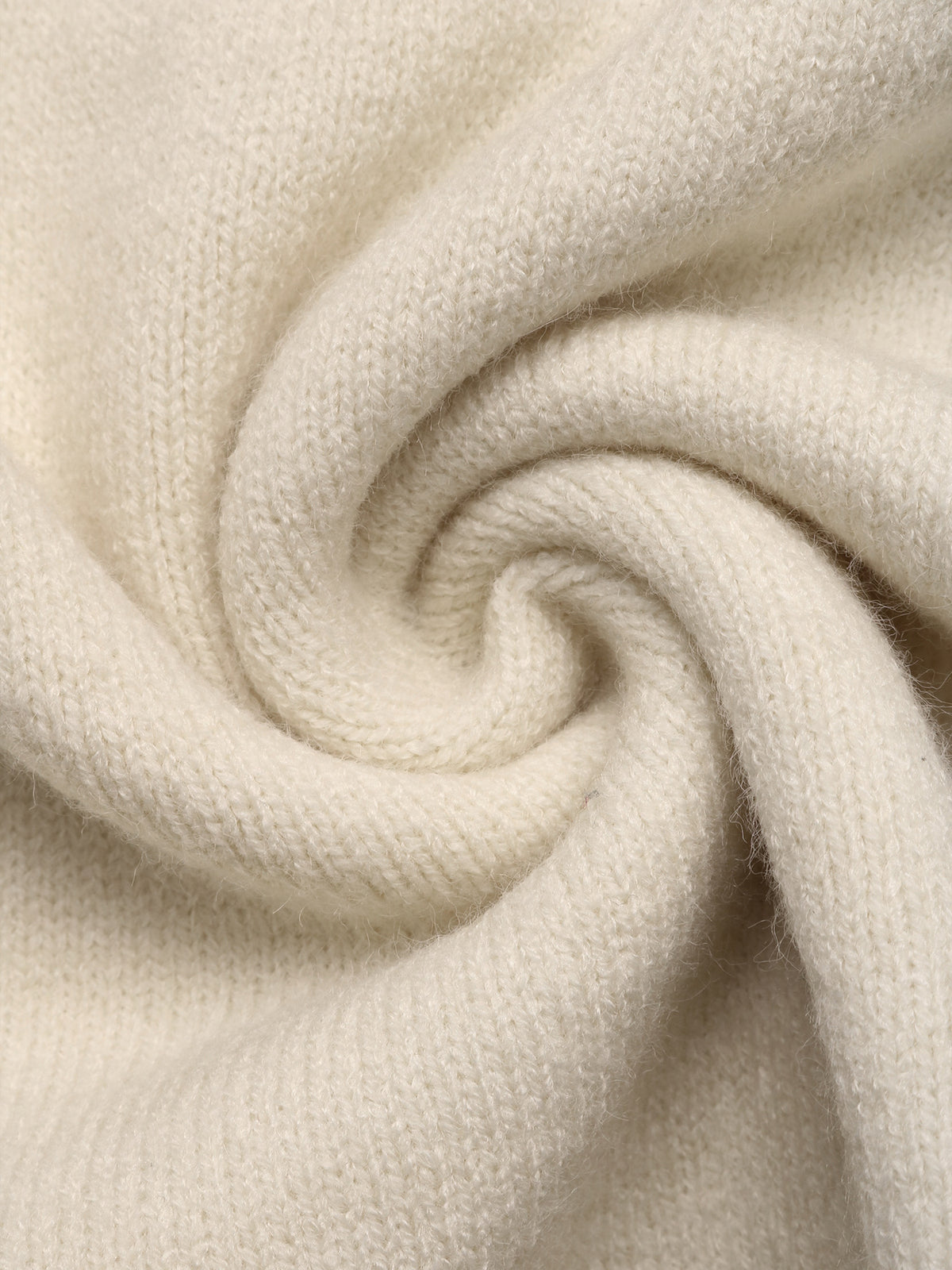 A close-up of soft cream-colored knit fabric, swirled into a spiral to show the texture and drape.