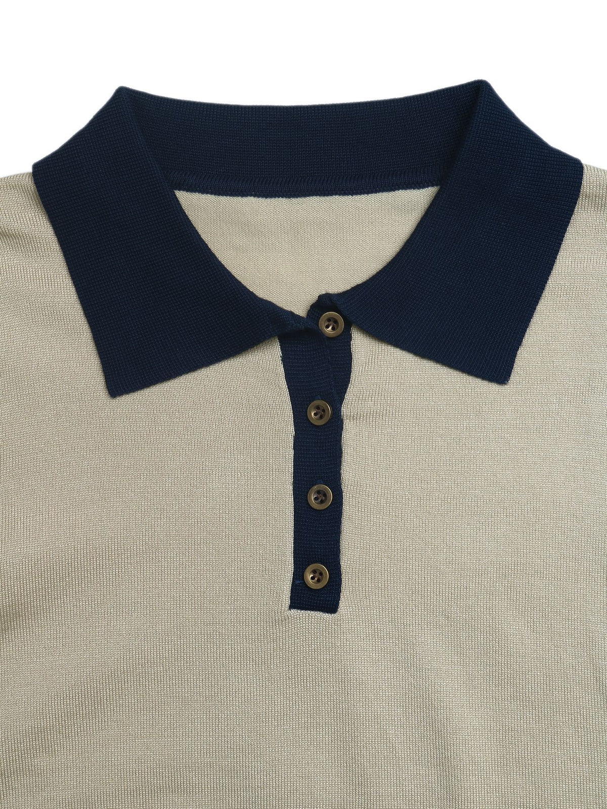 Close-up of a polo shirt collar and placket, featuring a dark navy blue collar and button placket with brown buttons over a light beige textured knit body.