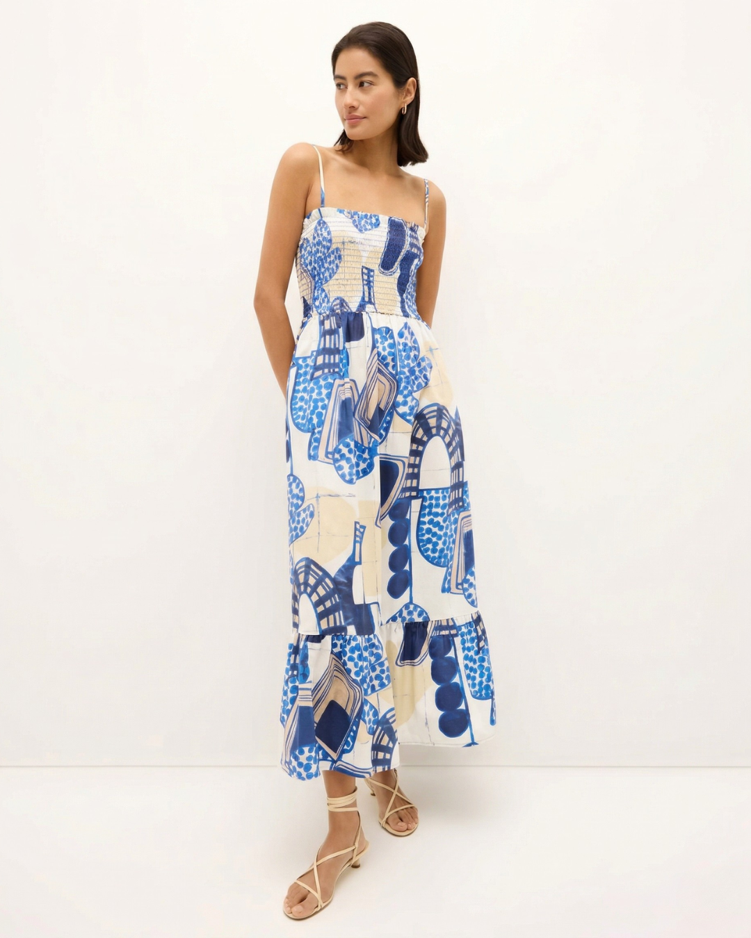 Woman wearing a blue and white patterned dress on a white background