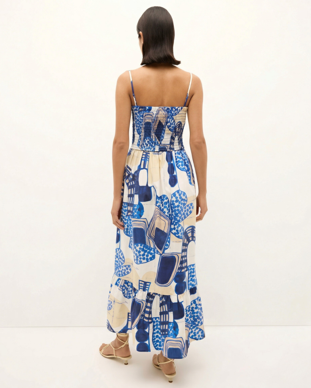 Woman wearing a blue and white patterned dress on a white background