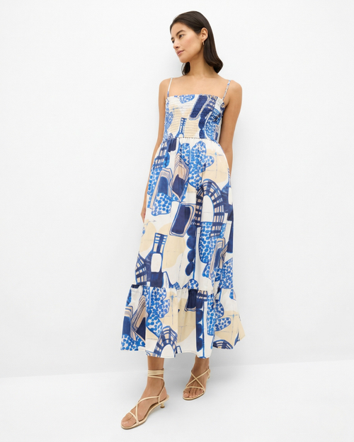 Woman wearing a blue and white patterned dress on a white background