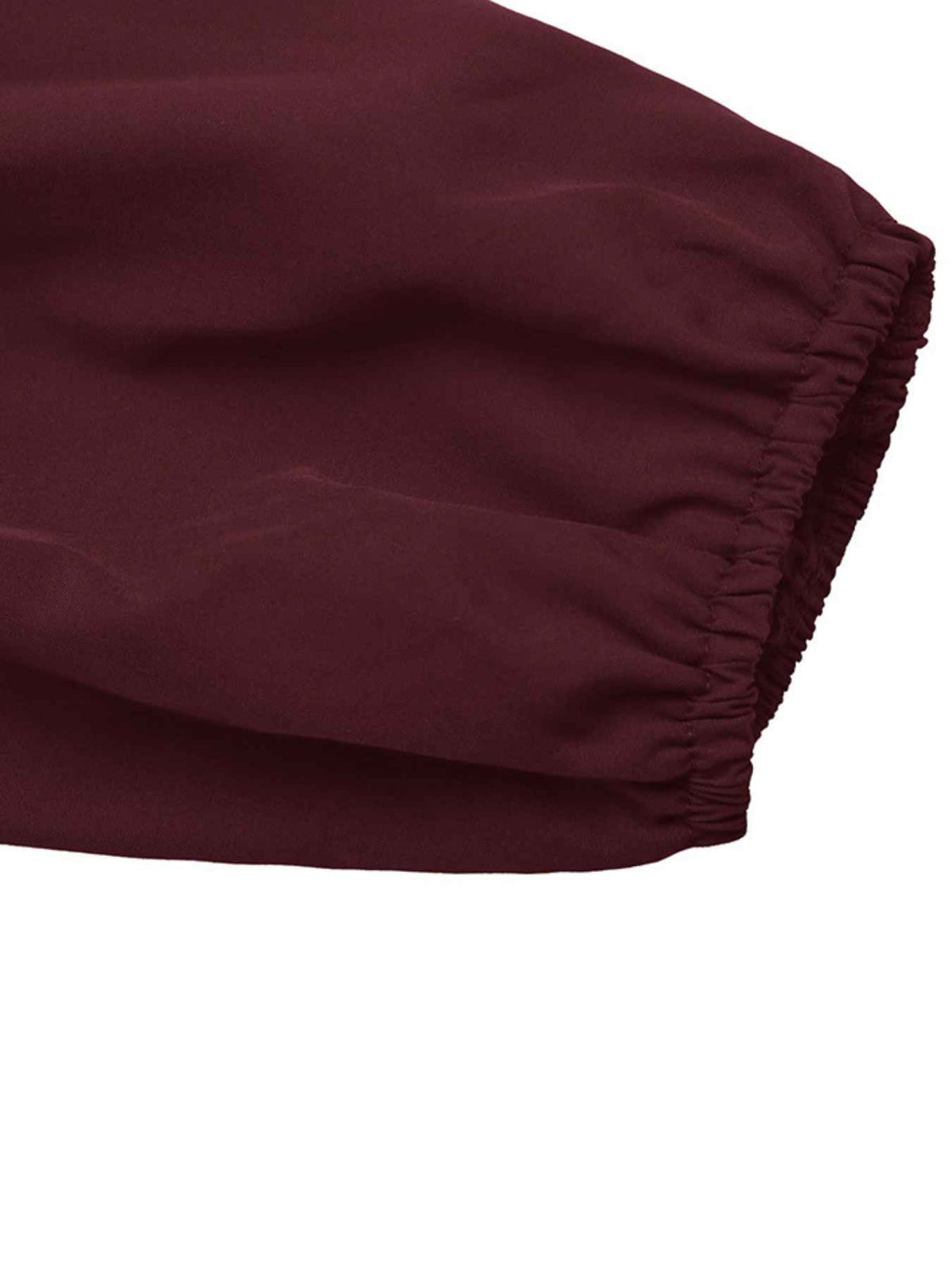 Close-up of a dark burgundy fabric sleeve with an elasticized cuff, shown against a plain white background.
