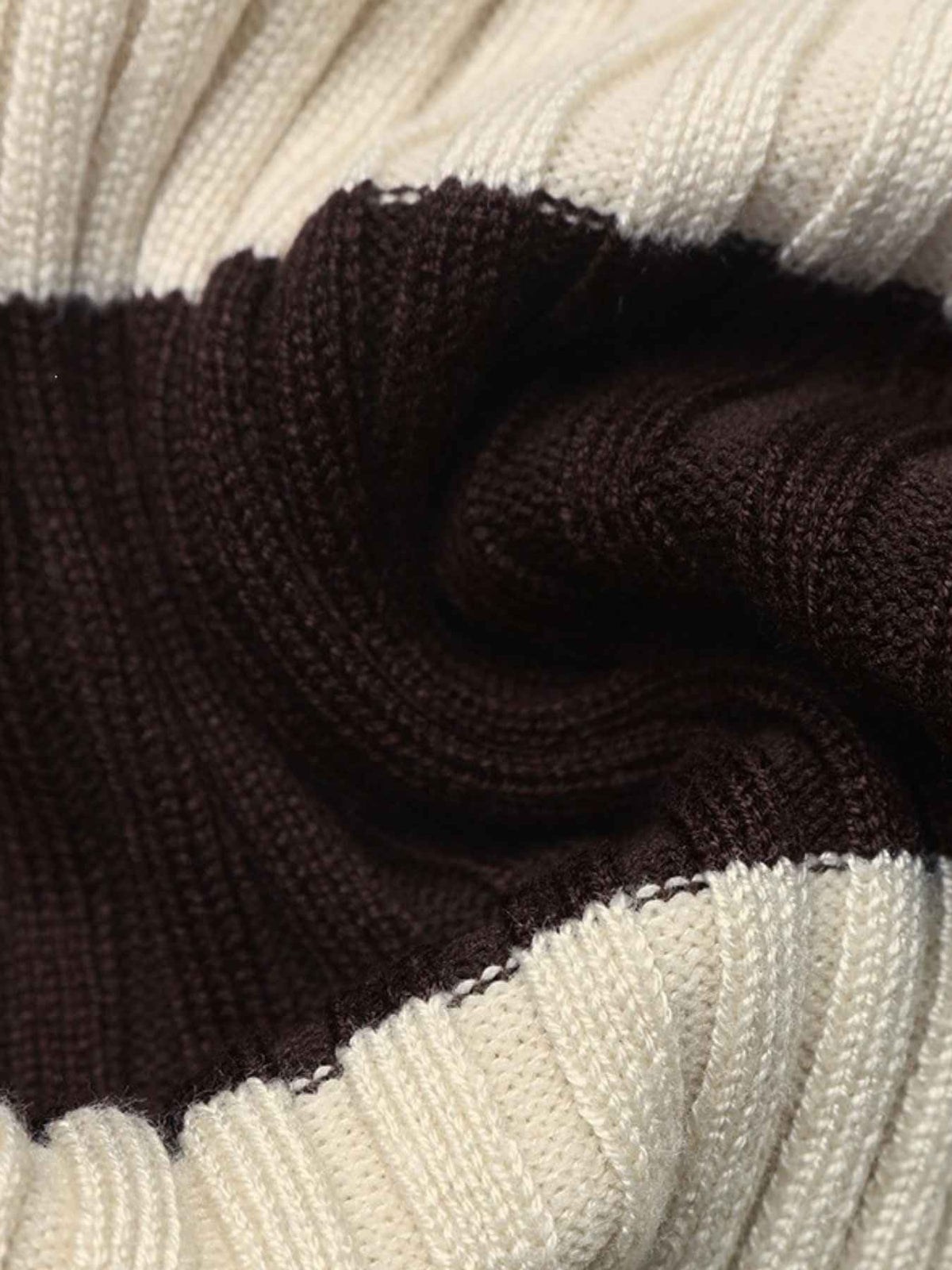 Close-up of a ribbed knit fabric with alternating horizontal stripes in cream and very dark brown.