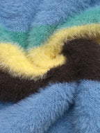 Close-up of a fuzzy, plush fabric with horizontal stripes in light blue, mint green, pale yellow, and dark brown.