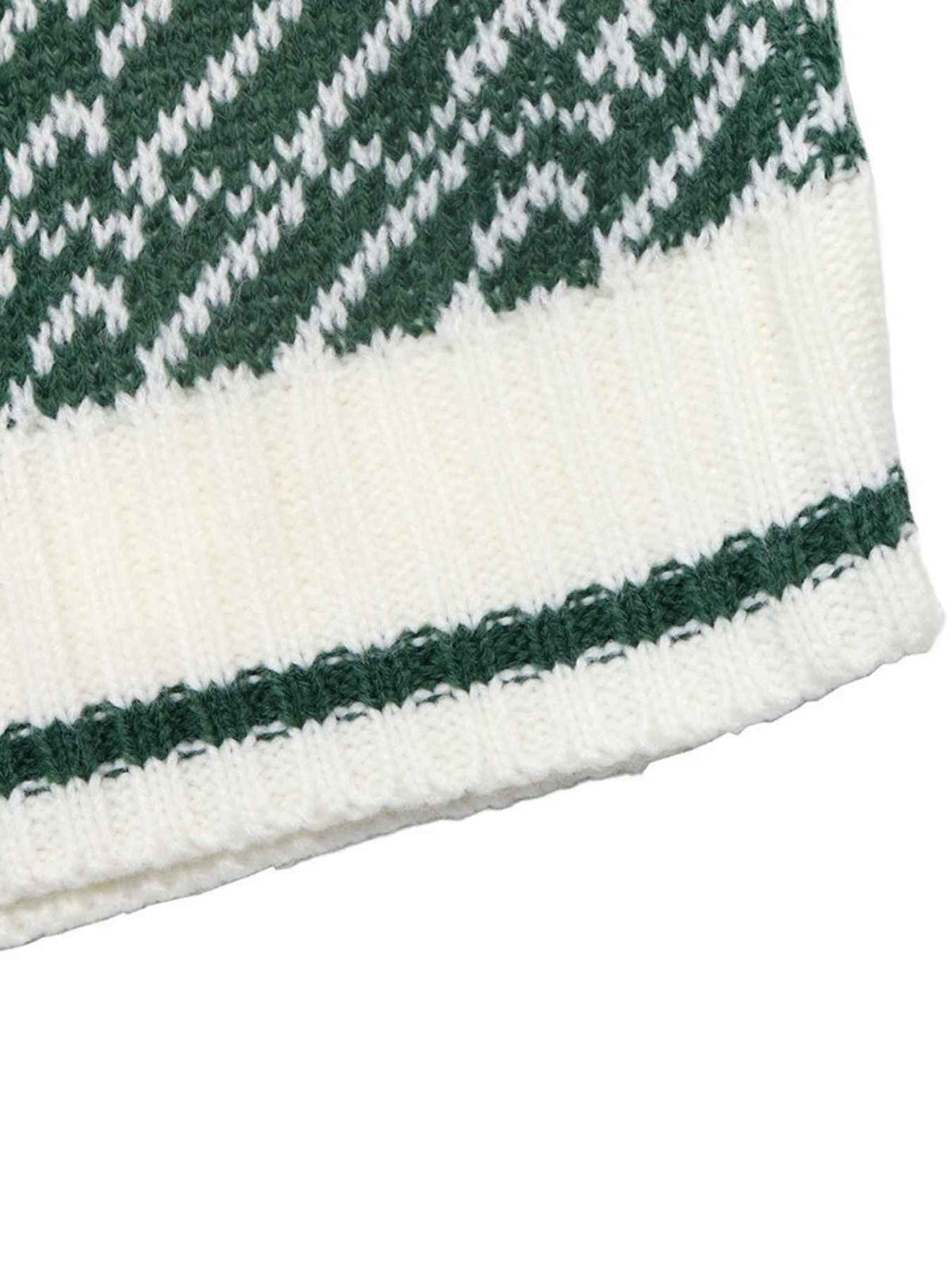 Close-up of a knit textile showing a green and white patterned section above a wide white ribbed band with a thin green stripe near the bottom.