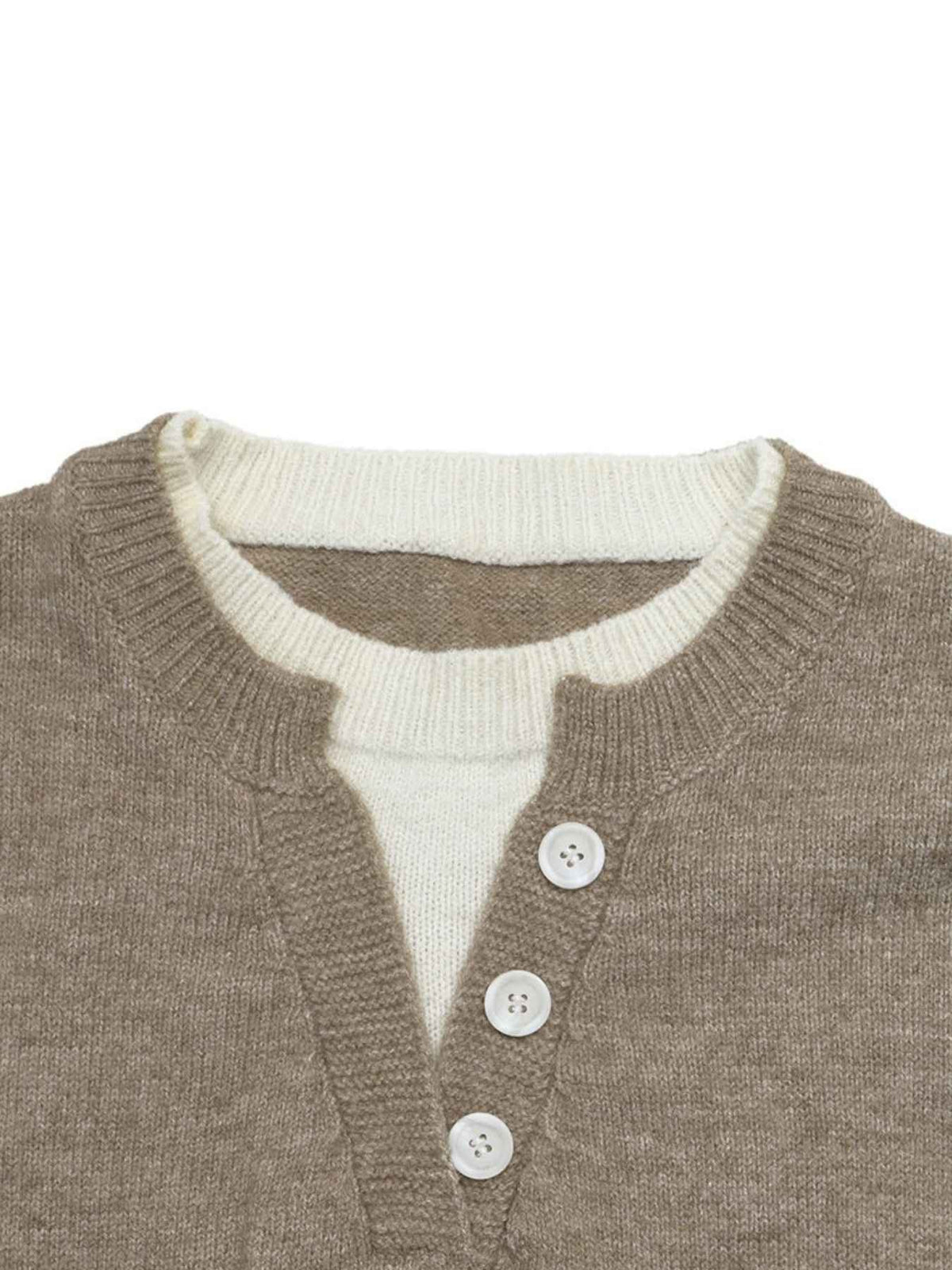 Close-up of a knit cardigan with a taupe-brown outer layer and an off-white inner layer, featuring three white buttons at the front.
