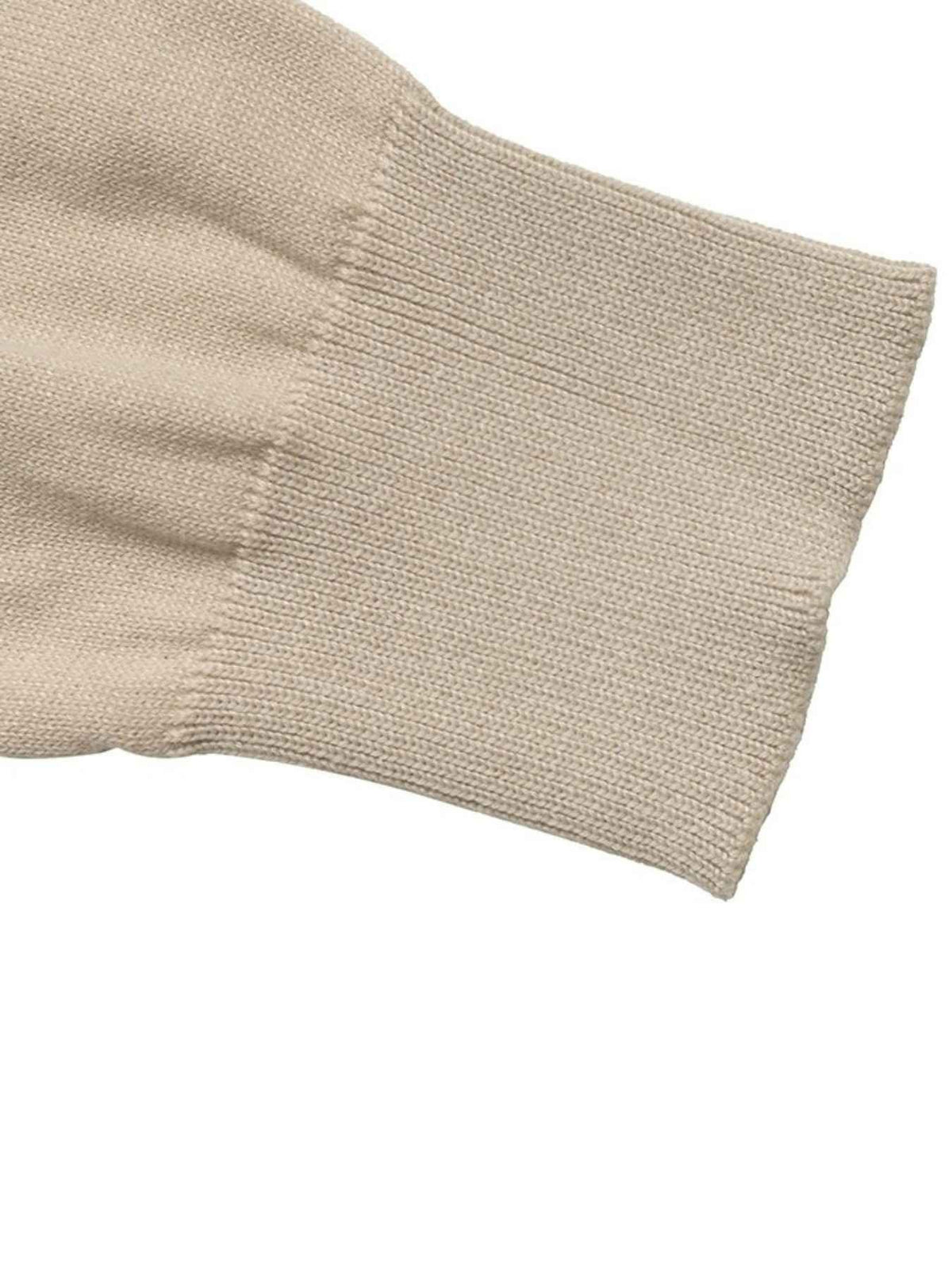 Close-up of a beige knit sleeve cuff showing the ribbed texture and stitching on a plain white background.