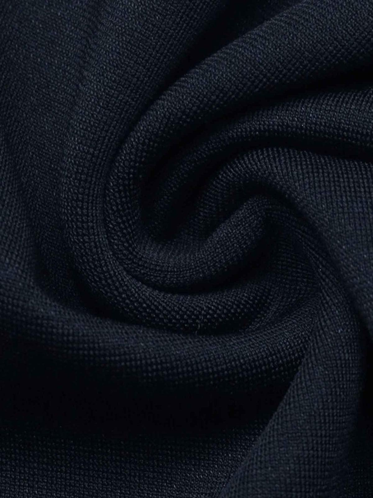 A close-up of dark navy blue textured fabric, shown with a soft spiral fold pattern.