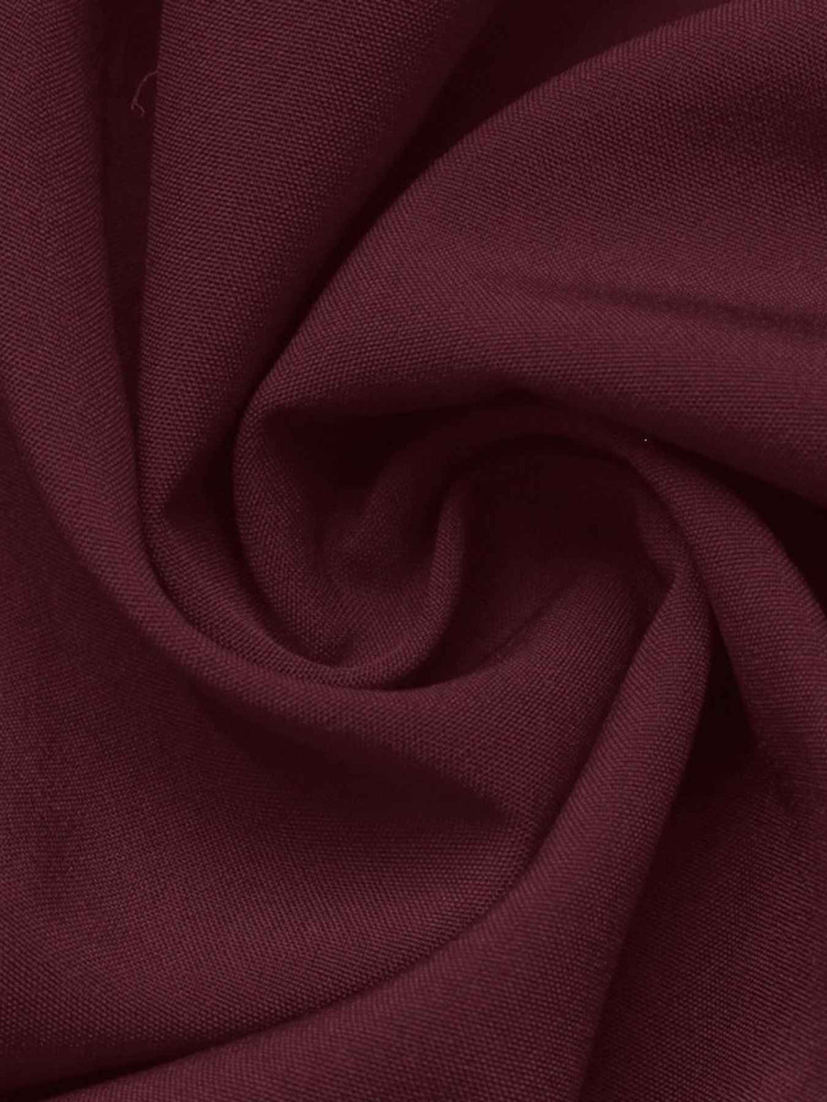 A close-up of draped burgundy fabric with a visible woven texture, arranged in soft folds.