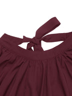 Close-up of a dark burgundy top with a tie-back neckline, showing the fabric texture and gathered waist details against a white background.
