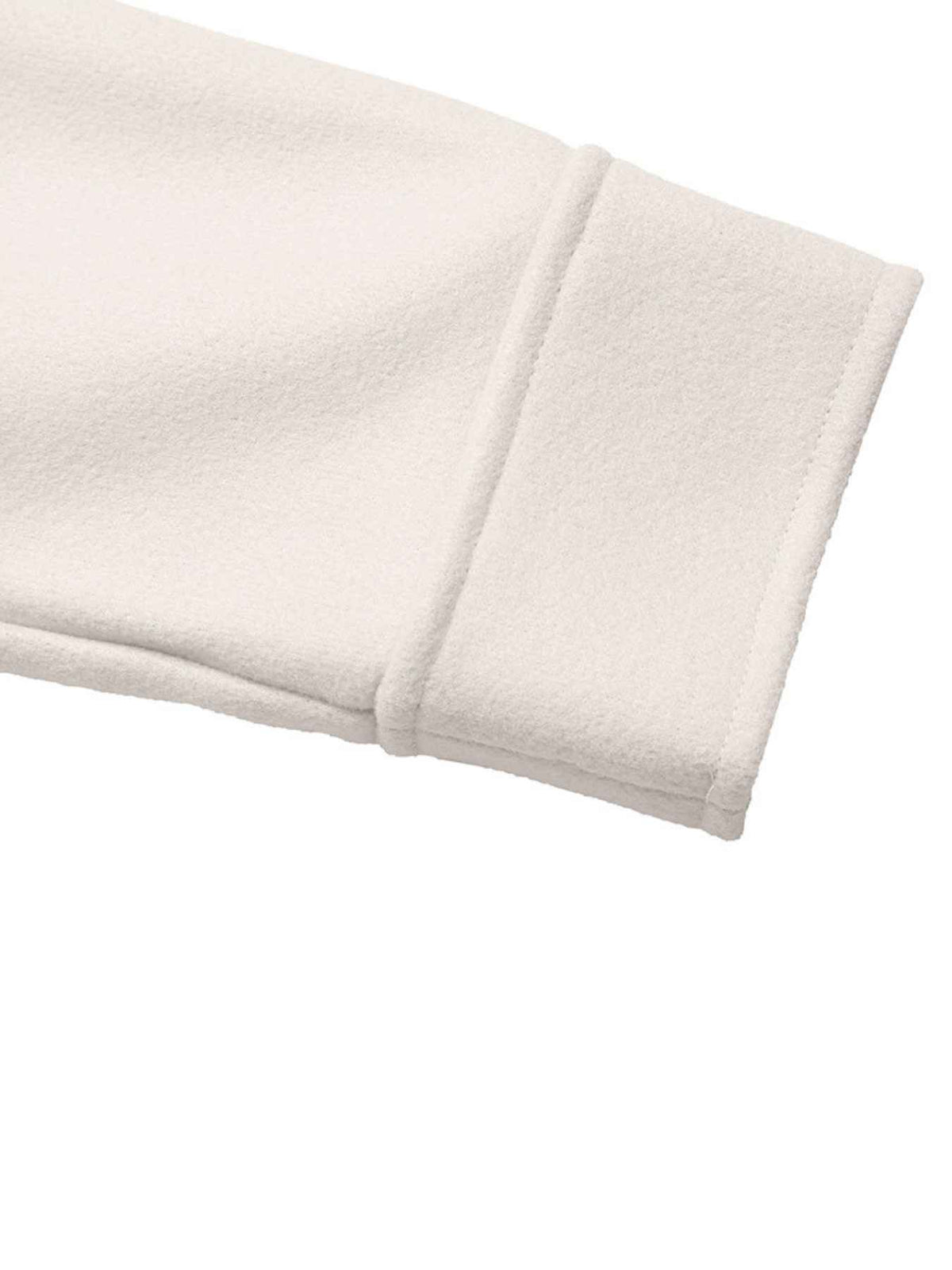 Close-up of a soft fleece or sweatshirt sleeve cuff in a warm off-white or cream color, showing the ribbed knit texture and folded hem against a plain white background.