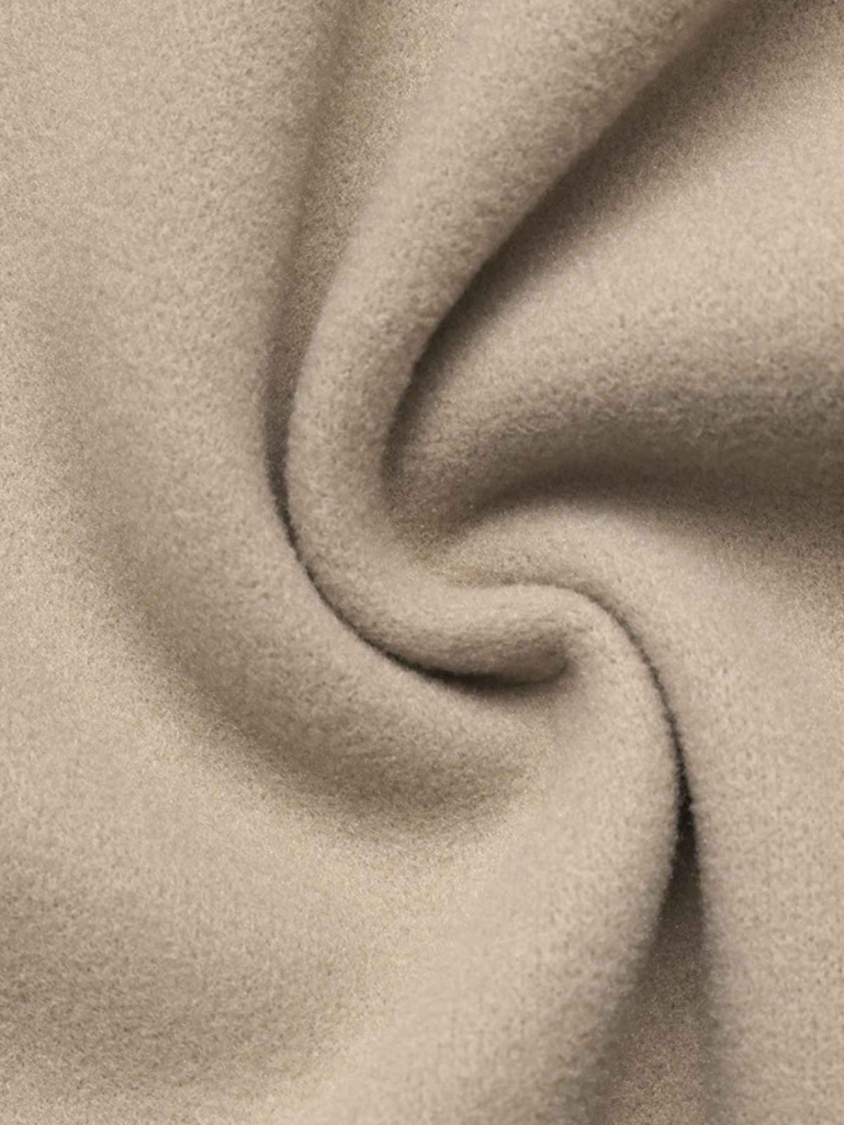 A close-up of soft, draped fabric in a warm light beige or oatmeal tone, showing the texture and folds.