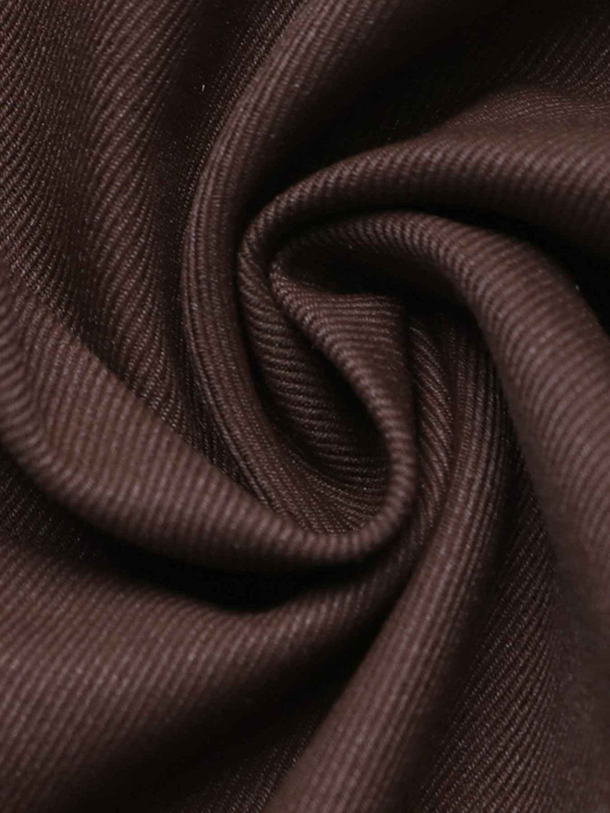 A close-up of dark brown textured fabric with a twisted swirl pattern, showing the fine ribbed weave detail.