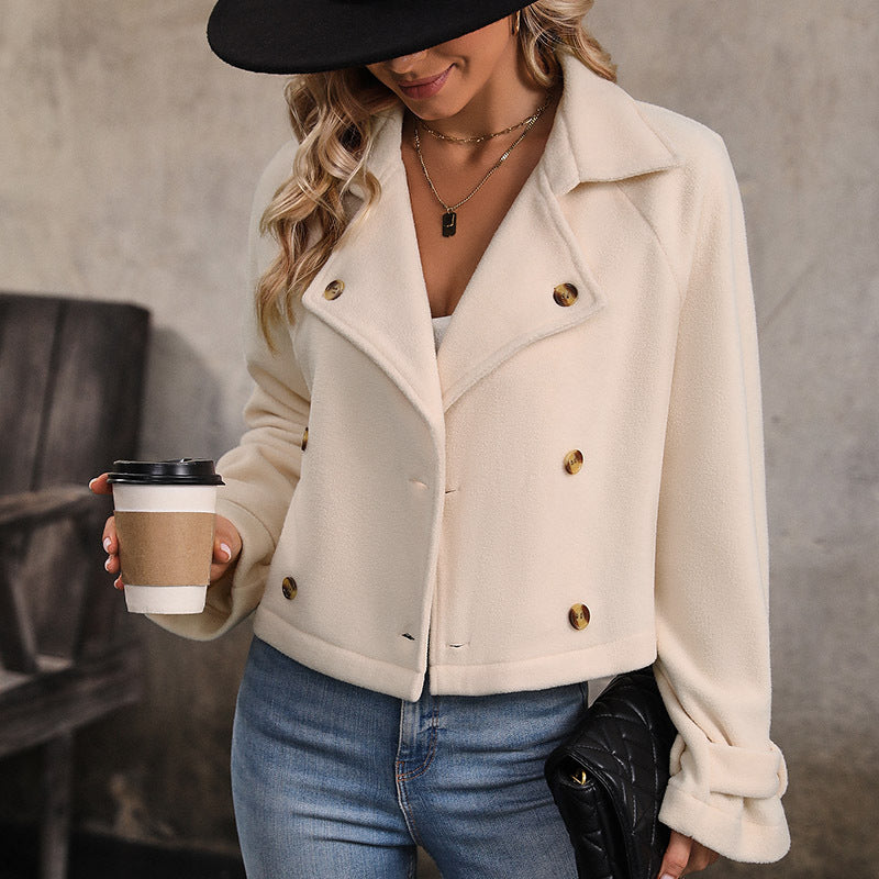 Cream double breasted jacket worn open with a white top and jeans