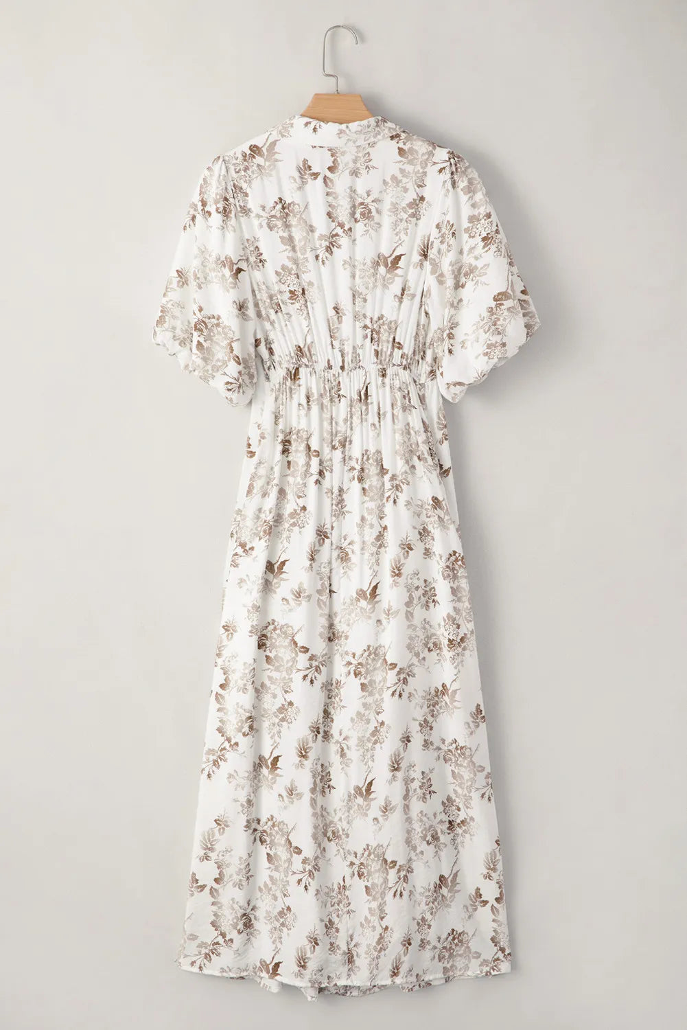 Floral dress on a hanger against a gray background
