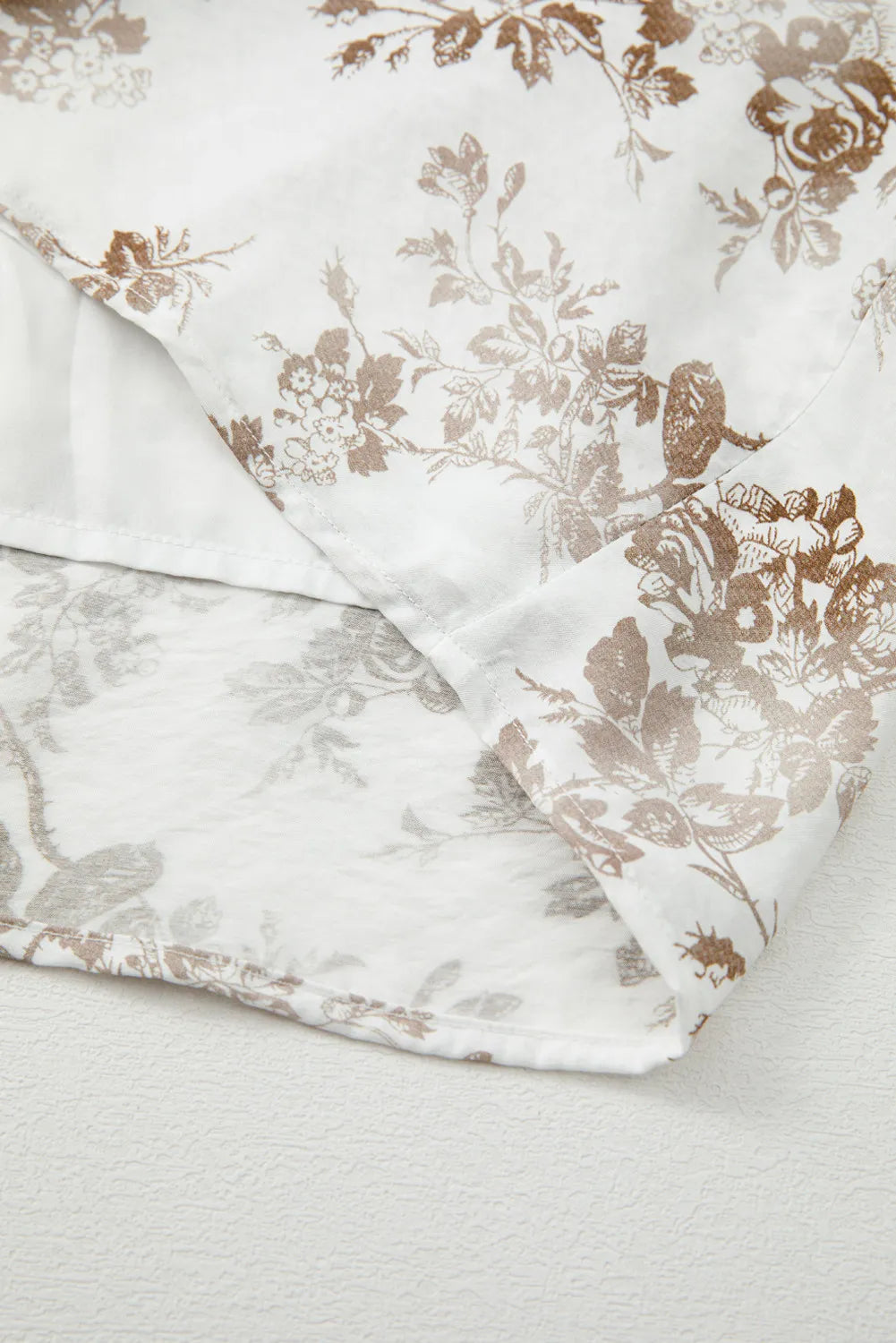 Floral patterned fabric with beige flowers on a white background