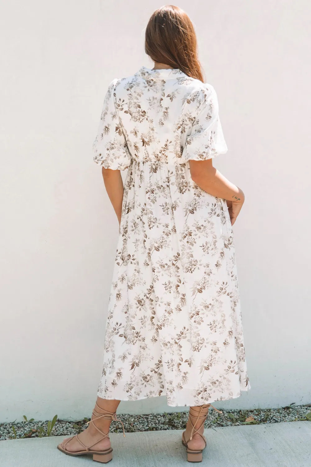 Woman wearing a floral dress against a plain background