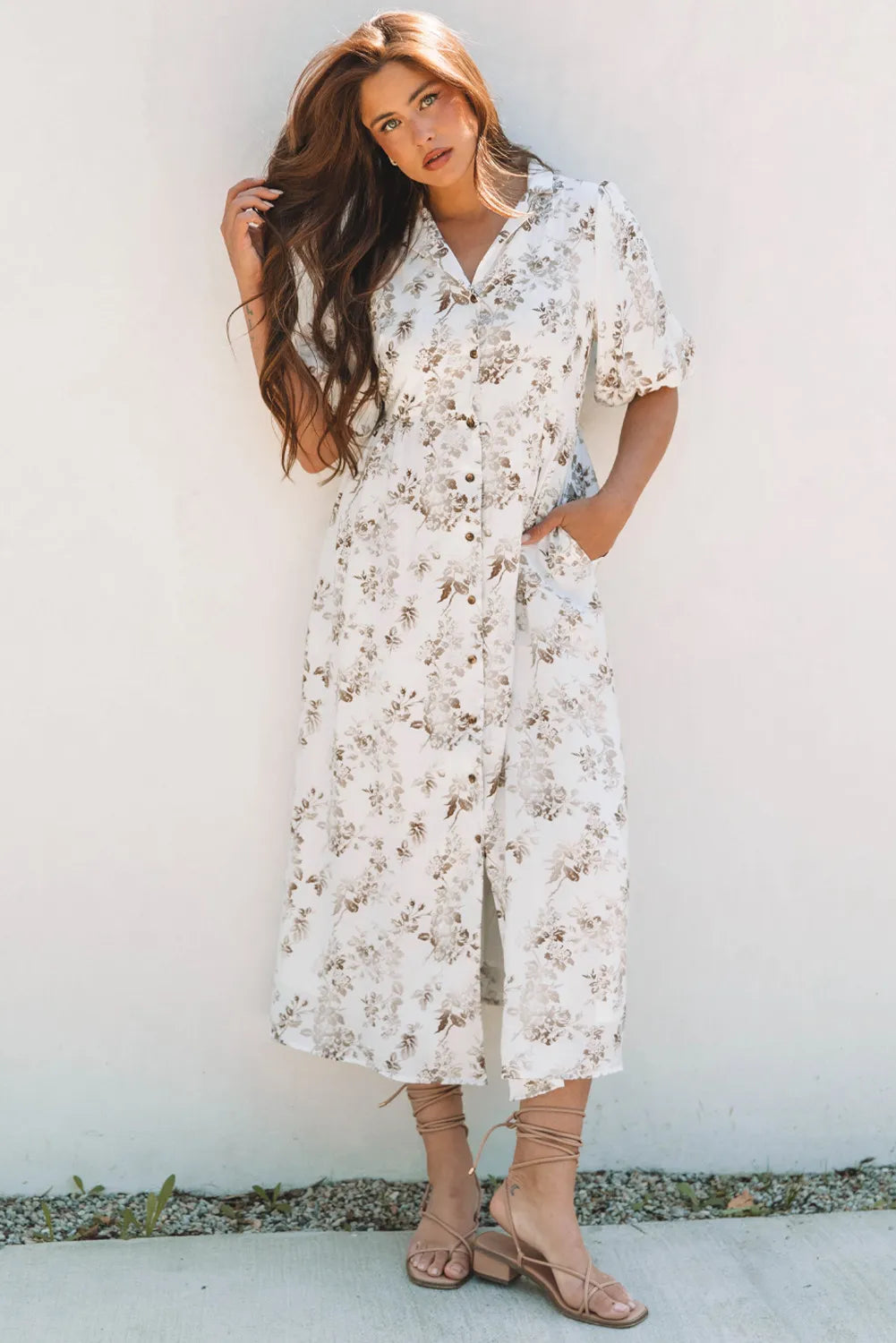 Woman wearing a white floral dress against a light background