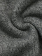 A close-up of a dark gray knitted fabric with a soft, textured weave, shown in a gentle swirl pattern.