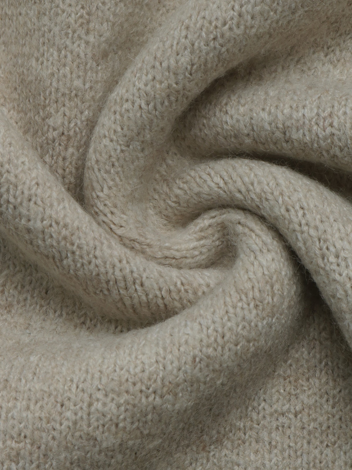 A close-up of a soft, knitted fabric in a light oatmeal beige color, arranged in a gentle spiral drape to show texture and flexibility.