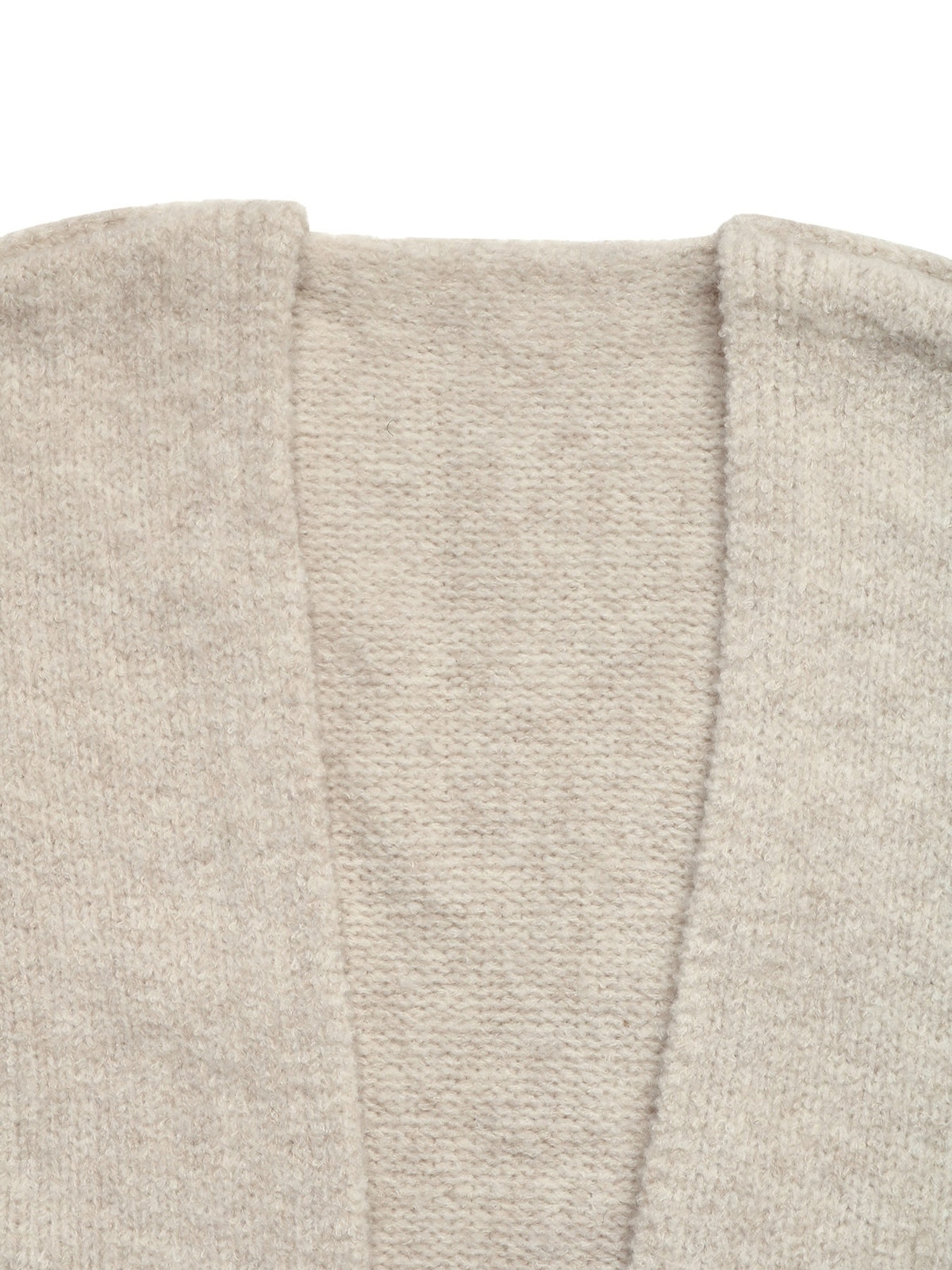 Close-up of a light beige knit garment showing the texture and neckline details against a white background.