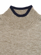 Close-up of a ribbed knit sweater neck in a heathered beige color with a contrasting dark navy ribbed collar trim, shown against a plain white background.
