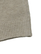 Close-up of a light taupe knit fabric with a ribbed cuff on a white background.