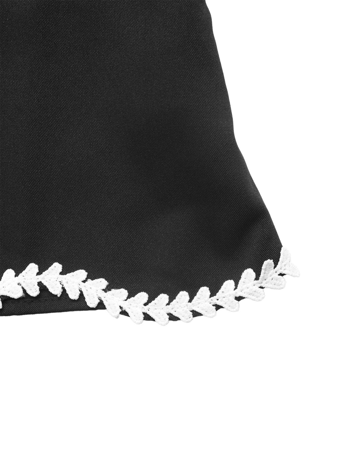 Close-up of a black fabric item with a white zigzag stitched or embroidered trim along the lower edge, shown against a white background.