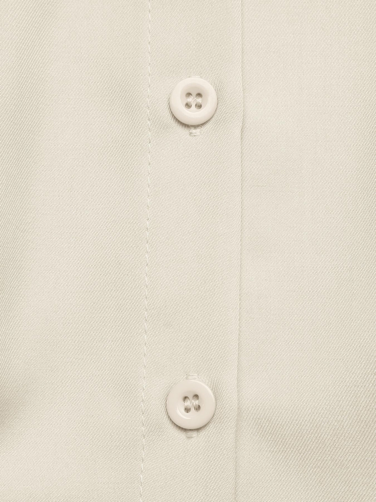 Close-up of a light cream or off-white button-down shirt fabric showing the button placket with two buttons.