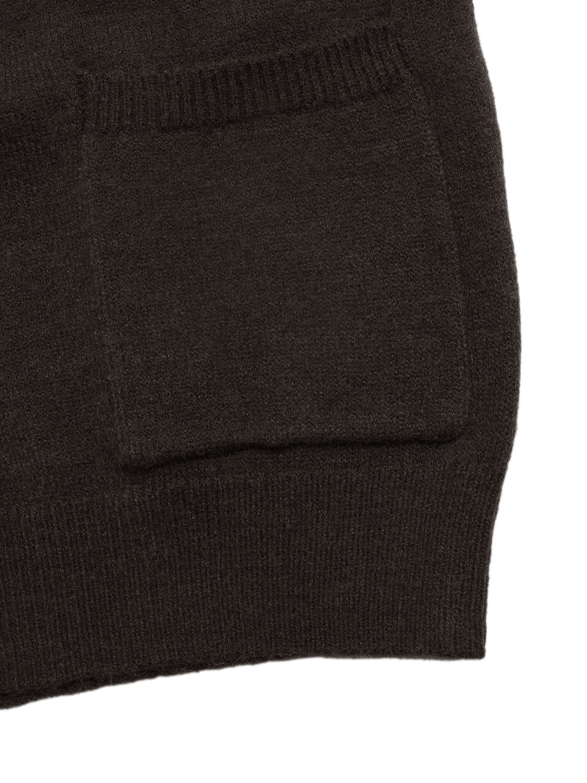 Close-up detail of a dark brown knit garment showing a ribbed pocket opening and hem against a white background.
