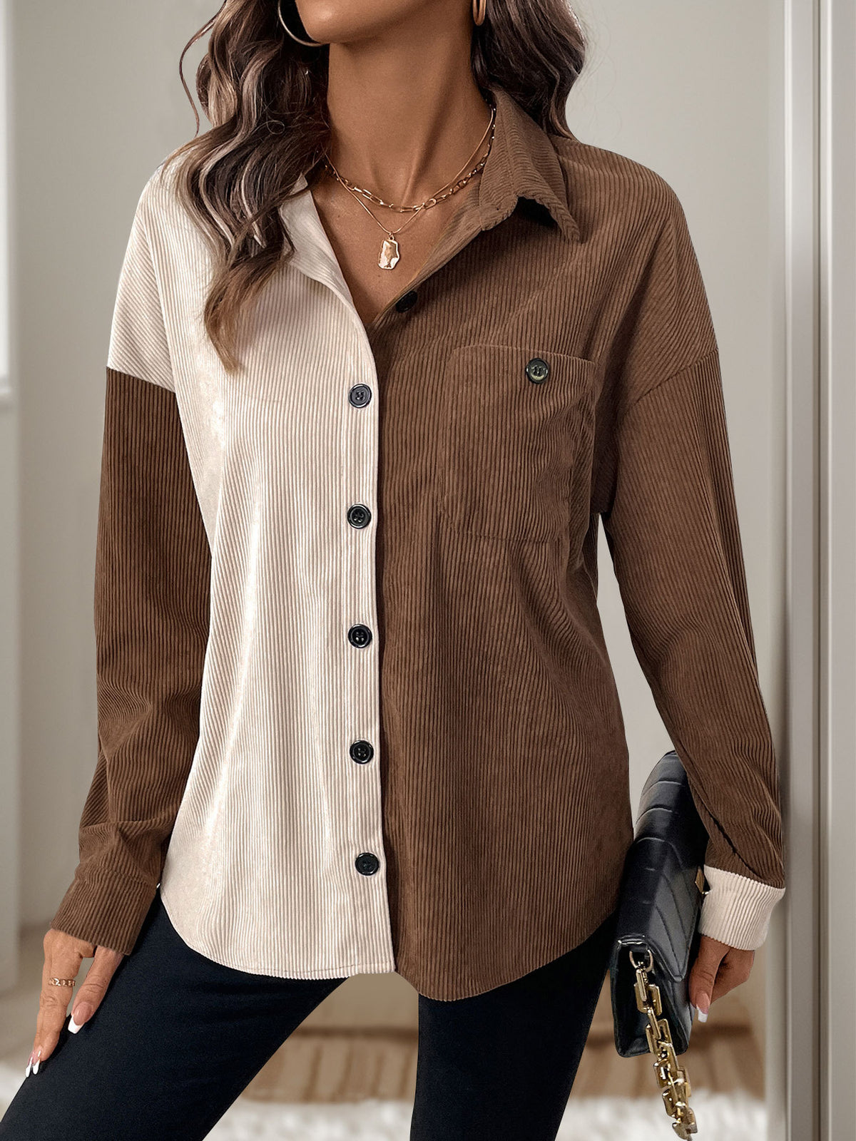 Woman wearing a brown and beige corduroy shirt with a neutral background