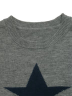Close-up of a gray knit sweater with a large dark navy star motif on the chest, showing the ribbed crew neck collar.