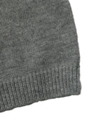 Close-up of a dark gray knit fabric with a ribbed cuff, shown against a plain white background.