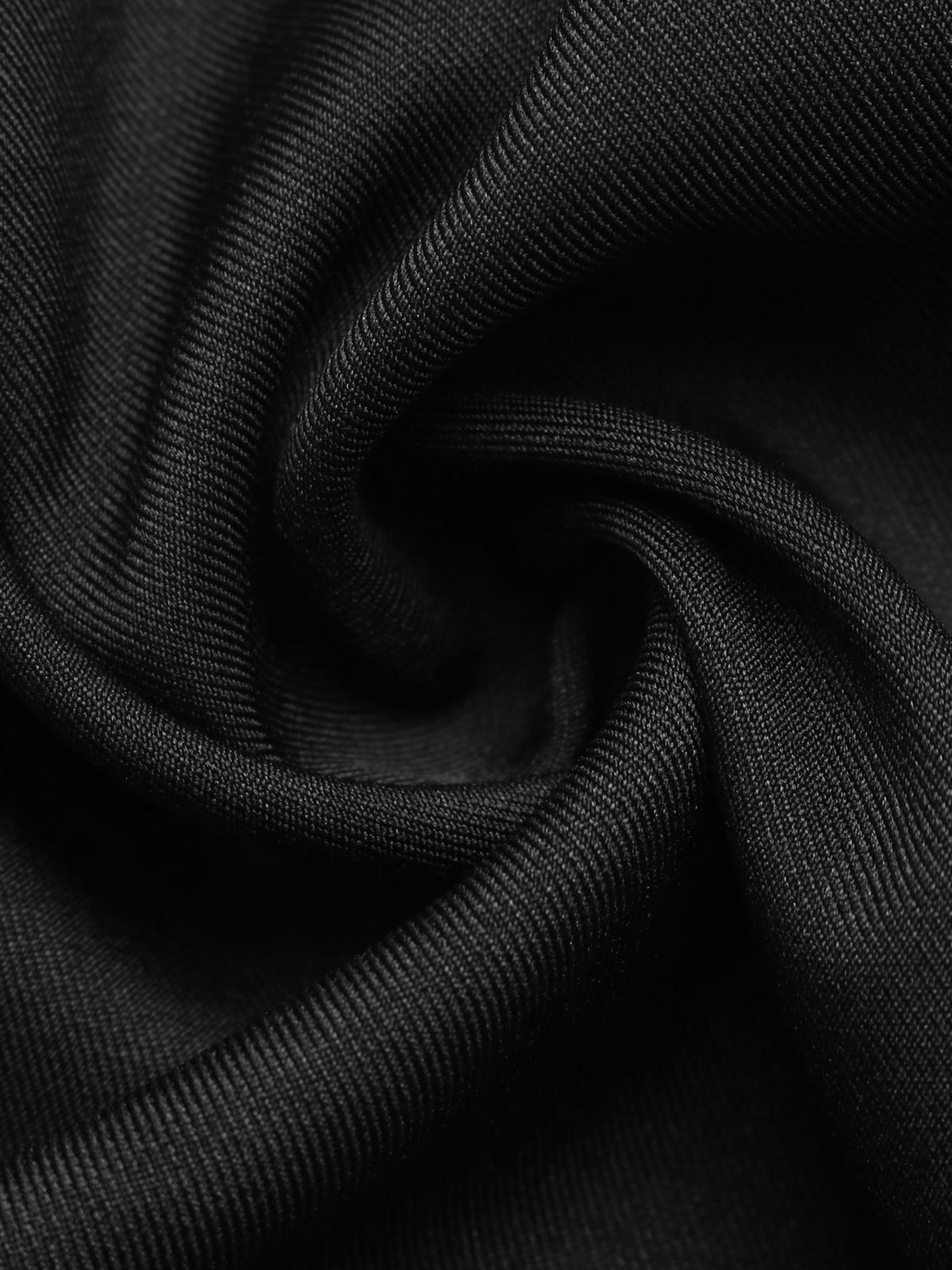 A close-up of black textured fabric with a fine ribbed or woven surface, arranged in soft folds and swirls.