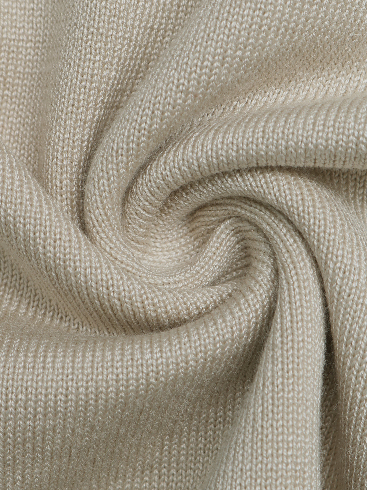 A close-up of a soft knit fabric swirled in a spiral, showing a fine ribbed texture in a warm light beige color.