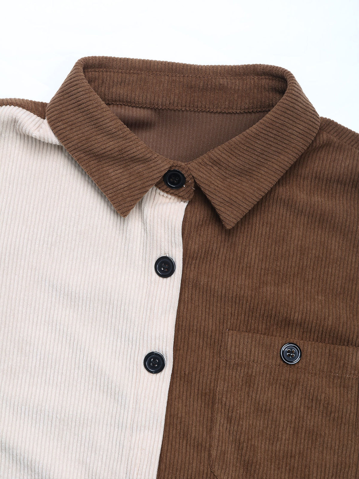 Close-up of a brown and white corduroy shirt with buttons on a white background
