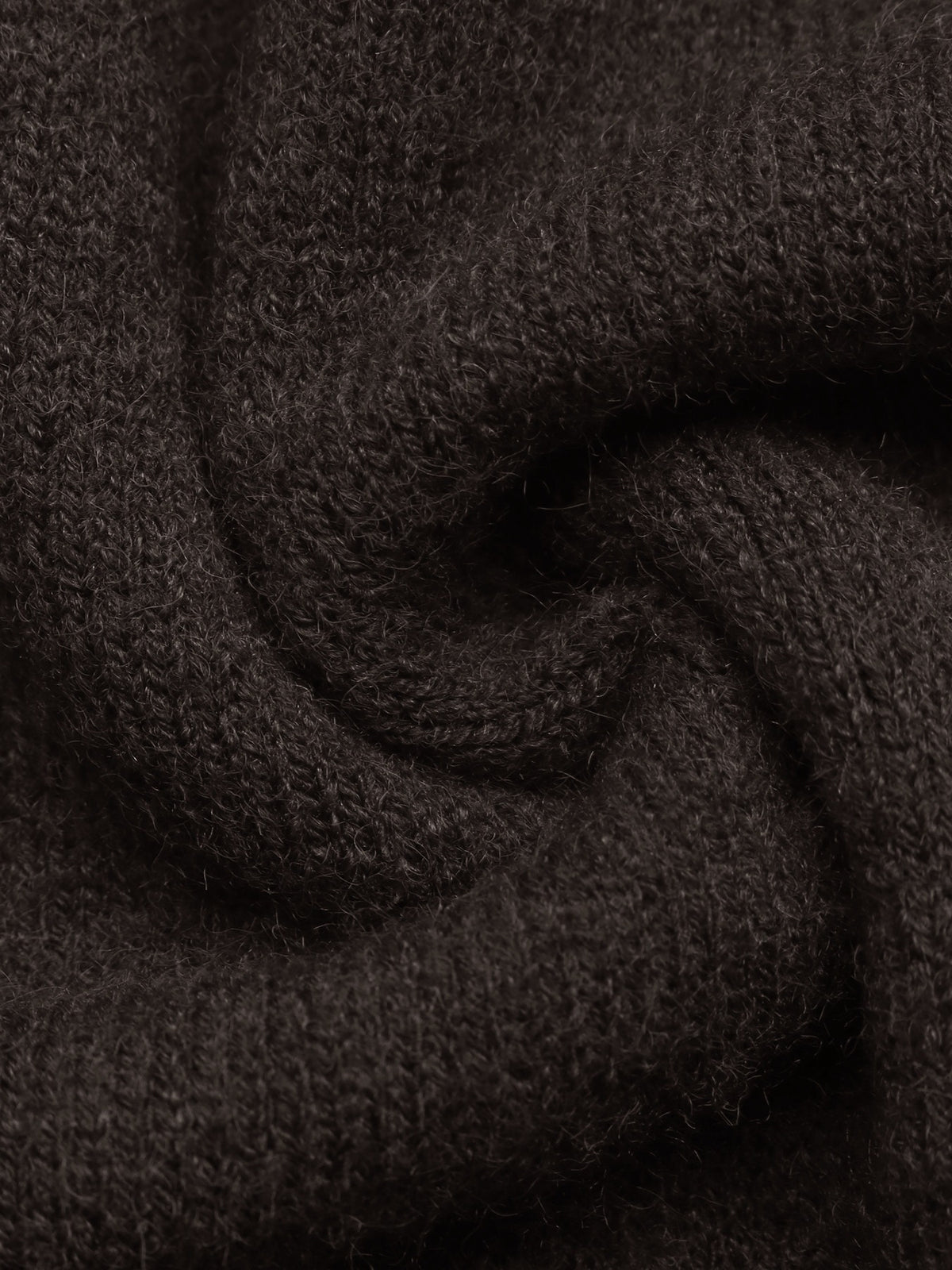 A close-up of dark brown textured knit fabric, shown with soft folds and a swirled arrangement.