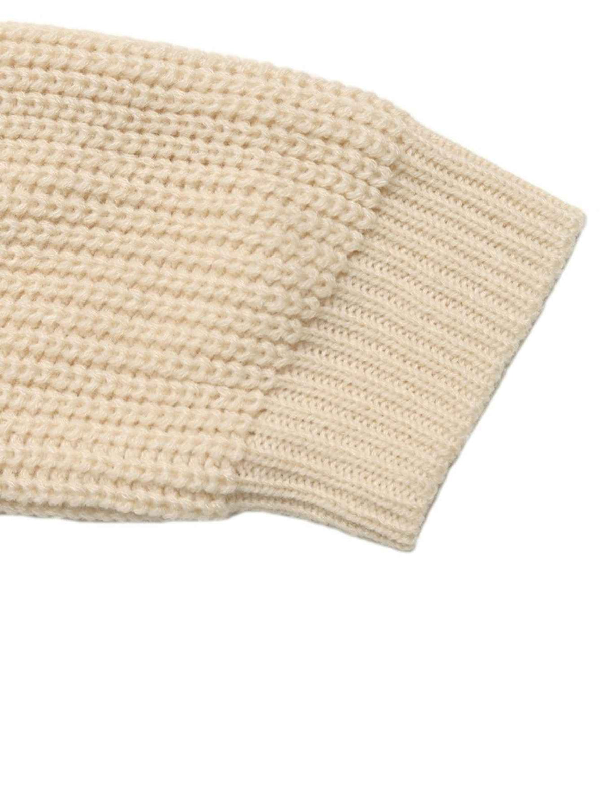 Close-up of a cream-colored chunky knit fabric with a ribbed cuff, shown on a plain white background.