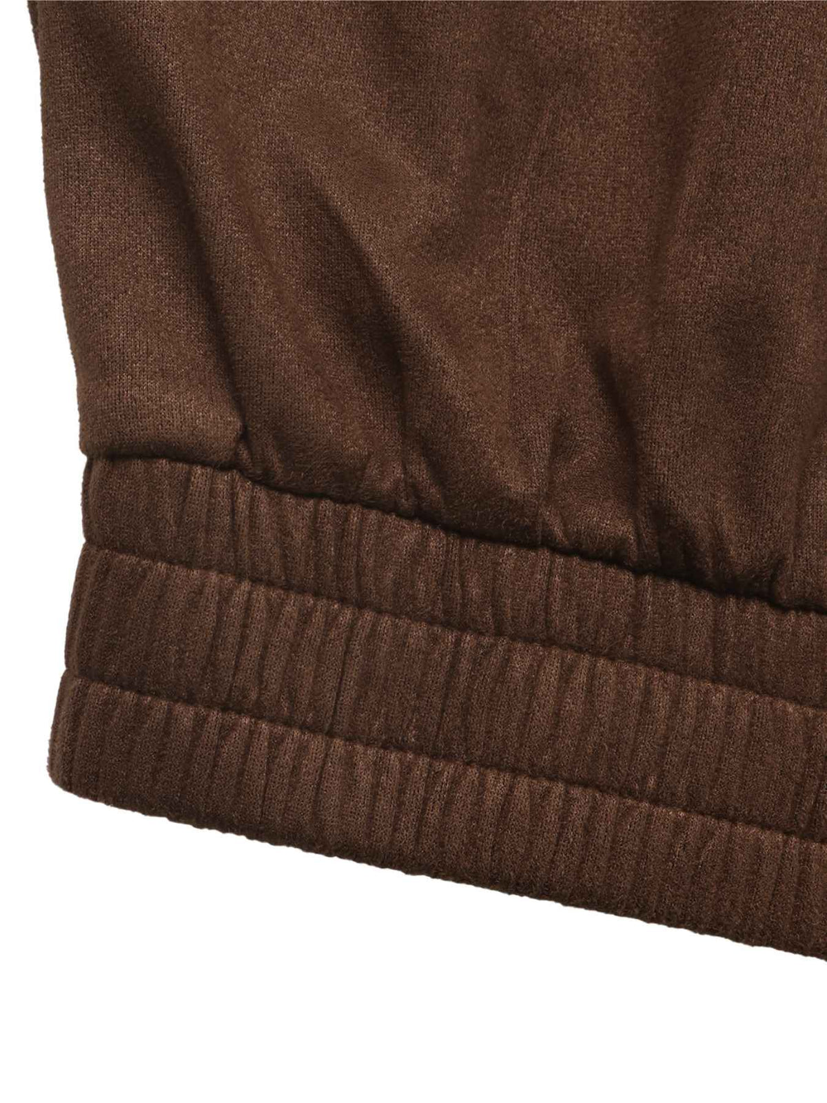 Close-up of a brown ribbed knit fabric cuff, showing the texture and elasticized edge of a garment.