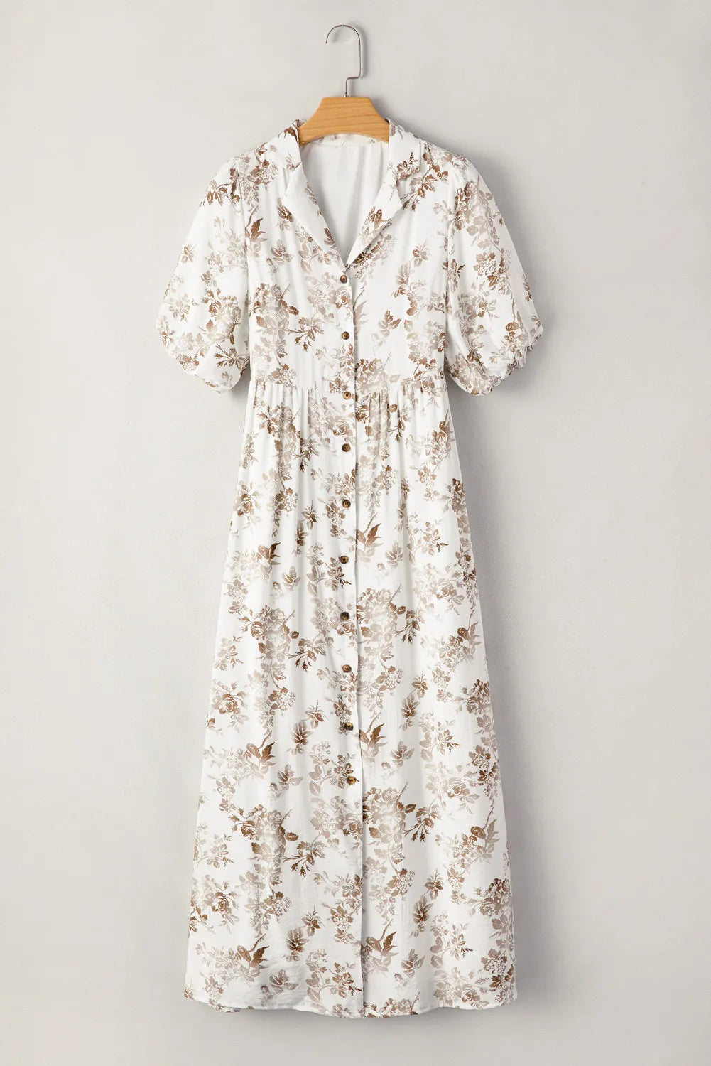 Floral dress on a hanger against a gray background